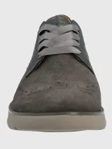 Zapato acordonado de gamuza color gris con perforaciones y detalles de picado inglés.
