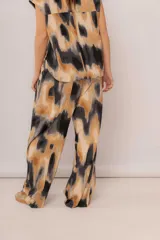 Pantalón de algodón con estampado abstracto en tonos beige, marrón y negro.