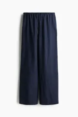 Pantalón de lino azul marino, de corte holgado, con cintura elástica ajustable con cordón, bolsillos laterales y traseros.