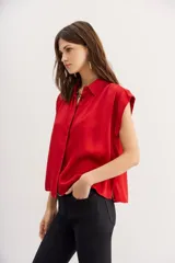 Camisa azul petróleo de viscosa y modal, manga corta, cuello camisero y frunces en los hombros.