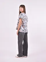 Blusa estampada con cuello en V y mangas cortas con volados.