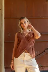 Blusa marrón cruzada confeccionada en tusor, sin mangas y con lazo interno para ajustar.