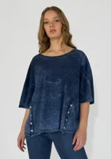 Remera color amarillo con cuello redondo y mangas cortas amplias, con detalle de botones en los laterales.