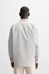 Camisa de hombre relaxed fit confeccionada en tejido de algodón a cuadros. Tiene cuello solapa, manga larga con puños abotonados, bolsillo en el pecho y cierre frontal con botones.