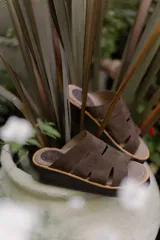 Sandalias marrones de gamuza con plataforma y tiras con aberturas.