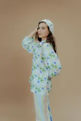 Camisa de mangas largas con puños elásticos y cuello clásico. Presenta un estampado a rayas verticales de colores pastel y cierre frontal con botones.