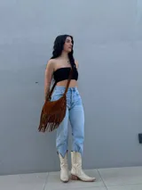Cartera de flecos en color marrón, diseñada para llevar al hombro.