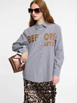Camisa a rayas con botón frontal y diseño gráfico en el pecho, de corte clásico.