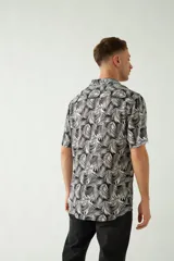 Camisa celeste con estampado de hojas, de corte slim, manga corta, cartera abotonada y logo bordado.