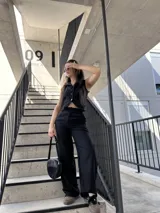 Conjunto negro de chaleco sastrero con botones y pantalón palazzo de tiro alto. El chaleco es entallado y el pantalón es de corte amplio.