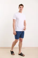 Short de baño azul marino con cintura elástica y cordón ajustable. Detalle de ribete blanco en el lateral.