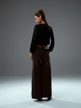 Top corto negro de satén con escote en V y mangas largas.