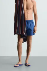 Short de baño azul con cintura elástica ajustable con cordón, bolsillos laterales y bolsillo trasero de plastrón.
