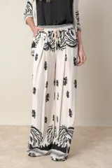 Pantalón palazzo de lino y viscosa color crudo con estampado de motivos vegetales en negro y marrón.