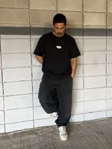 Pantalón de jean negro de corte ancho con costuras reforzadas en las rodillas.