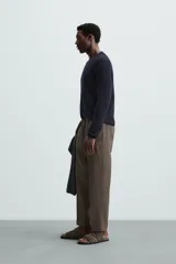 Pantalón negro de lino, corte recto y relaxed fit, con cintura elástica ajustable con cordón, bolsillos laterales y traseros.