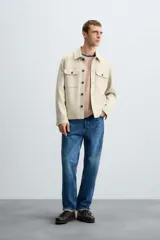 Sobrecamisa color beige de tejido efecto ante, corte regular fit, con cuello solapa, manga larga con puños abotonados, bolsillos de parche con solapa en el pecho y bolsillos de ojal en la cadera.
