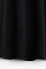 Musculosa negra de punto fino, corte entallado y escote en U en la parte delantera y trasera.