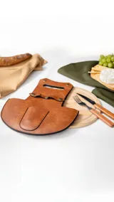 Set para parrilla que incluye plato de bamboo y estuche de símil cuero color marrón claro con ojal semi abierto y apertura con broches metálicos. Incluye juego de cubiertos con mango de madera.