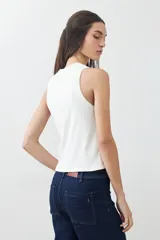 Musculosa color crudo de tejido de punto canalé, sin mangas y cuello redondo.