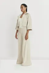 Pantalón de corte amplio color beige, con detalle de alforza central, recortes laterales y cintura elastizada en la espalda. Amplios bolsillos. Realizado en rústico liviano y fresco, con muy buena caída. Marca Zettia.