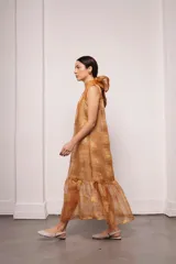 Vestido largo y amplio con cuello alto y mangas cortas abullonadas. Diseño a rayas verticales en tonos dorado y gris. Incluye viso liso al tono.