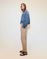 Babucha sastrera color beige confeccionada en tela italiana, de tiro medio y largo hasta los tobillos. Diseñada con cintura elastizada, cartera falsa, bolsillos laterales funcionales y piernas tipo pitillo con raya de aplomo.