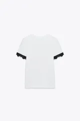 Camiseta blanca de algodón con cuello redondo y mangas cortas con detalle de encaje negro.