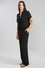 Pantalón negro de crepe con cintura elastizada, corte recto y bolsillos laterales.