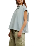 Remera estilo polo blanca de corte amplio con cuello clásico y botonadura corta en el frente. Tiene mangas cortas con dobladillo y aberturas laterales en el ruedo.