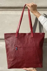 Bolso grande tipo tote de cuero color marrón con costuras decorativas en los laterales, forro interior con bolsillo para celular y bolsillo con cierre. Incluye bolsillo trasero con cierre y correas largas para colgar del hombro.