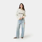 Sweater de punto grueso color blanco hueso, con cuello redondo, corte cuadrado y ligeramente corto. Presenta un gráfico frontal con el texto "EME STUDIOS curated by ben ice" en color marrón. Tiene puños ajustados.