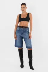 Bermuda de jean rígido, tiro medio, calce relax y proceso de lavado artesanal.