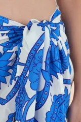 Pareo corto de playa con estampado floral en tonos azules y blancos.
