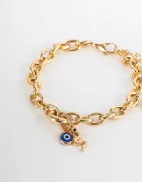 Pulsera dorada de cadena gruesa con dijes colgantes: un ojo turco y una serpiente.