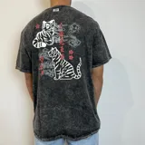 Remera negra con efecto gastado, corte holgado y estampado trasero con dos tigres, flores y texto en japonés.