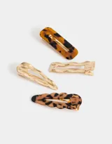 Set de cuatro hebillas para el pelo en acrílico con diferentes formas y estampados carey y dorado.