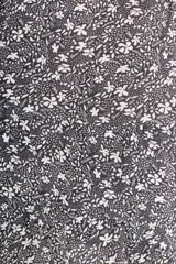 Vestido corto con estampado floral en blanco y negro, cuello camisero, mangas largas abullonadas y falda evasé con detalle de borlas.