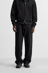 Pantalón jogger gris de corte recto, confeccionado en tejido de algodón compacto con interior en rizo. Cuenta con cintura elástica ajustable con cordón interior, bolsillos frontales y bolsillo de doble vivo en la espalda.