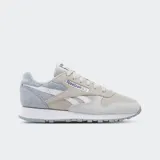 Championes Reebok Classic Leather en tonos gris, beige y blanco, con capellada de cuero y gamuza, forro textil, entresuela de EVA y suela de goma.