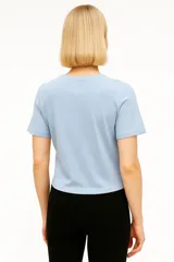 Remera blanca de algodón con estampado de flores en un jarrón.