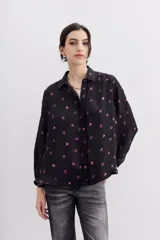 Camisa fluida negra con estampado de corazones color lila, mangas largas, cuello camisero y puños con botón.