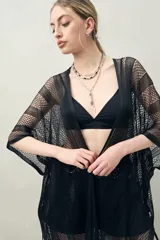 Poncho de hilo color beige con diseño calado y flecos en el ruedo.