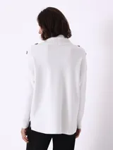 Sweater blanco de punto con cuello alto y botones decorativos en los hombros.