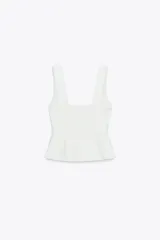 Top blanco de escote pico y tirantes anchos con detalle de picueta a tono y abertura en el bajo.