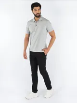 Chomba gris de manga corta, confeccionada en algodón y poliéster, con cuello clásico y tapeta de dos botones. Presenta un monograma de Calvin Klein bordado en el pecho.