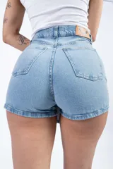 Short pollera de jean celeste con diseño cruzado y cierre con botón.
