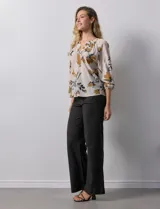 Blusa de gasa verde con estampado floral blanco y celeste, cuello a la base con escote en V y mangas 3/4 fruncidas.