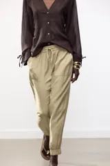 Pantalón jogger marrón de tiro alto con cintura elástica ajustable con cordones, bolsillos delanteros y puños elásticos en los tobillos.