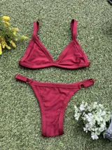 Conjunto de bikini bordó con corpiño triangular fijo y bombacha colaless regulable. Incluye abertura para agregar tazas soft.